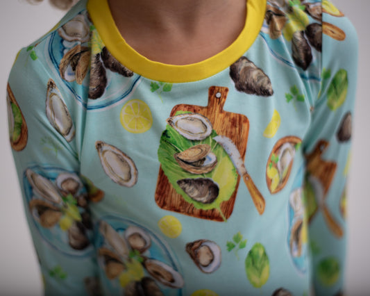 oyster pajamas on blue background and yellow trim